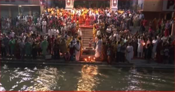 Grande folla di fedeli e visitatori riunita sulle scalinate lungo il fiume Gange durante la cerimonia dell'Aarti